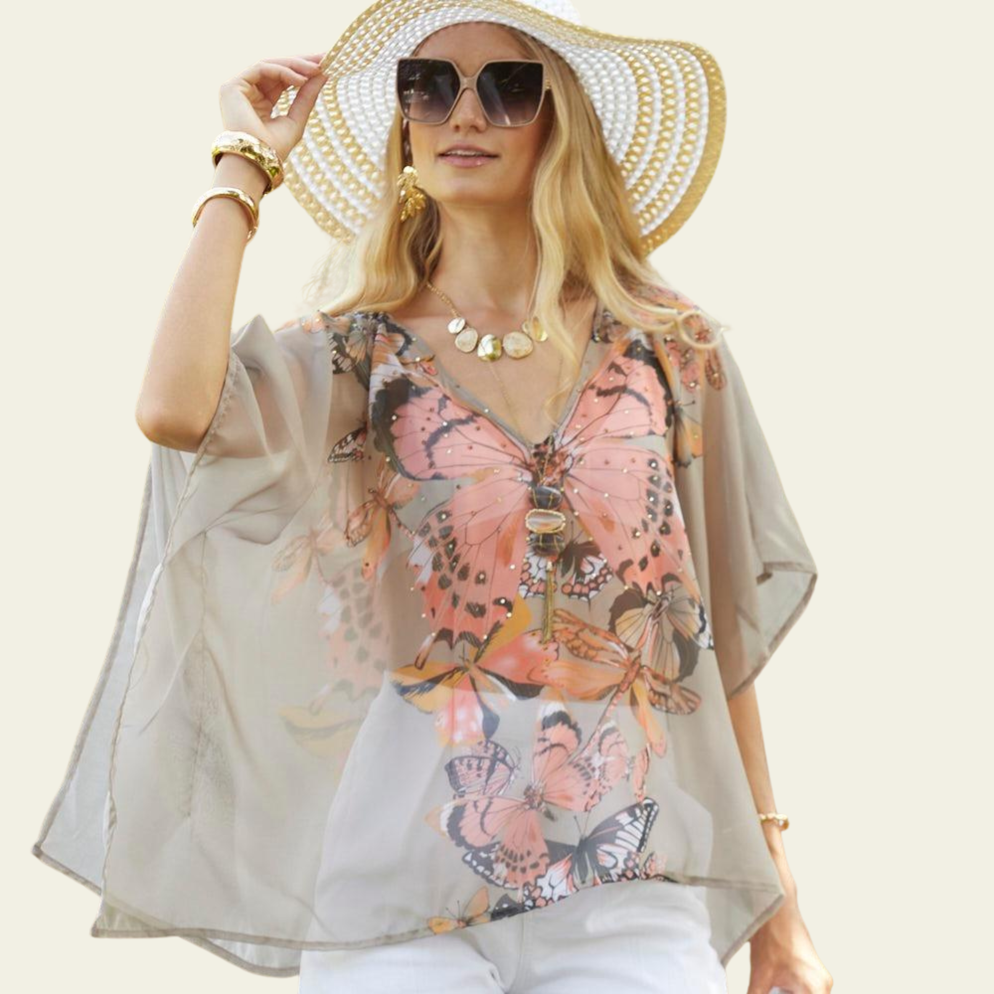 The Bijoux Terner Crystal Top Breathable Blouse is elegantly worn by the model, showcasing its lightweight fabric and graceful drape. The blouse flows effortlessly, highlighting its airy and breathable quality, perfect for warm weather. The design features a vibrant butterfly print in a mix of colorful hues, with shades of taupe that complement the intricate details of the butterflies.